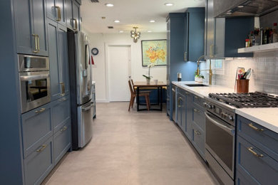 Example of a large minimalist galley porcelain tile and gray floor kitchen design in Houston with an undermount sink, shaker cabinets, blue cabinets, quartz countertops, blue backsplash, porcelain backsplash, stainless steel appliances and white countertops