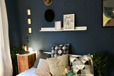 Kleines Eklektisches Hauptschlafzimmer mit blauer Wandfarbe, Laminat und braunem Boden in München
