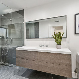 Large trendy 3/4 gray tile and porcelain tile porcelain floor and gray floor bathroom photo in San Francisco with light wood cabinets, white walls, an integrated sink, quartz countertops, white countertops, flat-panel cabinets and a two-piece toilet