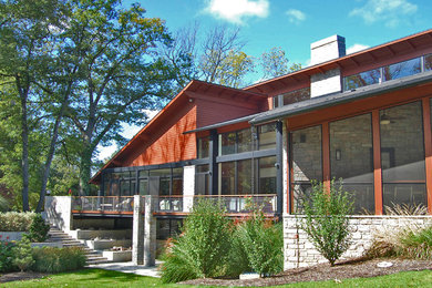 Large minimalist red two-story mixed siding house exterior photo in Other with a shed roof and a shingle roof