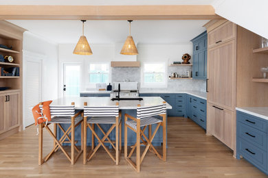 Inspiration for a coastal l-shaped eat-in kitchen remodel in San Diego with an undermount sink, shaker cabinets, blue cabinets, paneled appliances, an island and white countertops