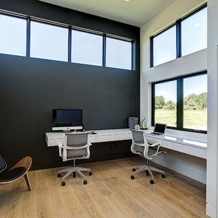 Mid-sized contemporary study room in Grand Rapids with black walls, light hardwood floors, a built-in desk, no fireplace and beige floor.