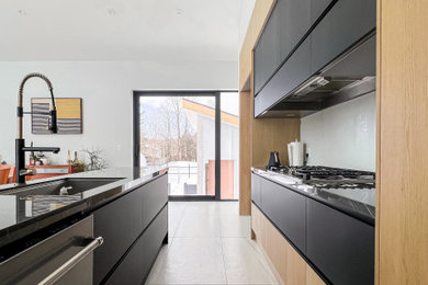 Open concept kitchen - mid-sized modern single-wall open concept kitchen idea in Toronto with flat-panel cabinets, light wood cabinets and an island