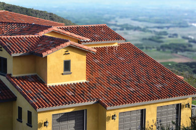 他の地域にある地中海スタイルのおしゃれな家の外観 (黄色い外壁) の写真