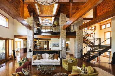 Example of a mountain style medium tone wood floor and exposed beam living room design in Kansas City