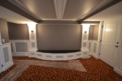 Inspiration for a huge transitional walk-out carpeted, brown floor, tray ceiling and wainscoting basement remodel in Bridgeport with a home theater and gray walls