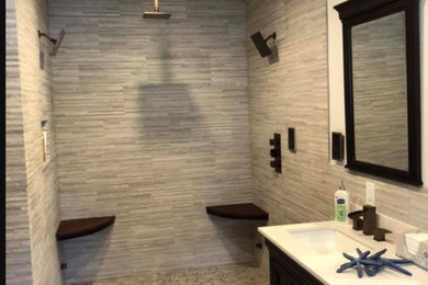Example of a mid-sized trendy master gray tile and porcelain tile porcelain tile and gray floor bathroom design in Philadelphia with furniture-like cabinets, black cabinets, a two-piece toilet, white walls, an undermount sink, quartz countertops and white countertops