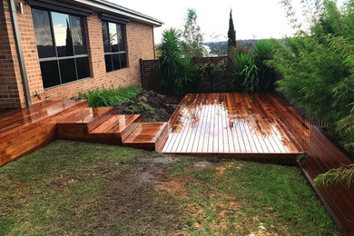 This is an example of a mid-sized modern backyard deck in Melbourne with a pergola.