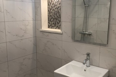 Mid-sized modern master bathroom in New York with shaker cabinets, black cabinets, a double shower, a one-piece toilet, white tile, stone tile, white walls, a console sink, tile benchtops, a shower curtain, white benchtops, a single vanity, a floating vanity, black floor and vaulted.
