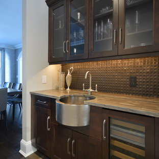 This is an example of a large transitional single-wall kitchen pantry in New York with quartzite benchtops, metallic splashback, metal splashback, stainless steel appliances, a farmhouse sink, shaker cabinets, grey cabinets, marble floors and brown floor.