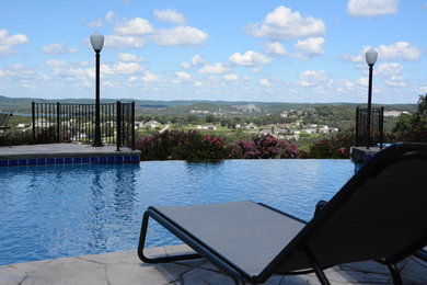 Pool - mid-sized traditional backyard stone and round pool idea in St Louis