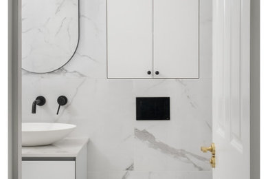 Inspiration for a medium sized contemporary ensuite wet room bathroom in Other with white cabinets, a wall mounted toilet, white tiles, ceramic tiles, ceramic flooring, a console sink, engineered stone worktops, white floors, an open shower, white worktops, a wall niche, a single sink and a floating vanity unit.