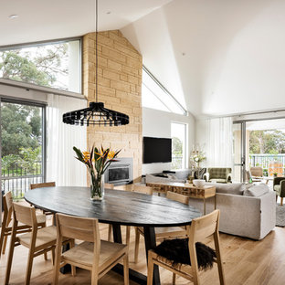 ジーロングの中サイズのモダンスタイルのLDKの画像 (白い壁、淡色無垢フローリング、標準型暖炉、石材の暖炉まわり、茶色い床)