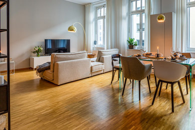 Modernes Wohnzimmer mit beiger Wandfarbe und braunem Holzboden