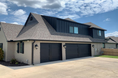 Mid-sized transitional one-story brick and board and batten exterior home idea in Other