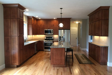 Elegant l-shaped light wood floor eat-in kitchen photo in Boston with a double-bowl sink, shaker cabinets, dark wood cabinets, granite countertops, stainless steel appliances and an island