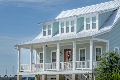 Inspiration for a beach style two-storey green house exterior in Other with concrete fiberboard siding, a gable roof, a metal roof, a grey roof and clapboard siding.