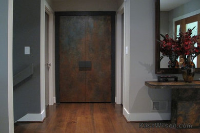 Exemple d'un couloir tendance avec un mur gris et un sol en bois brun.