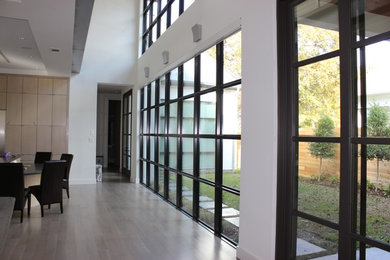 Dining room - large contemporary light wood floor and beige floor dining room idea in Dallas with white walls