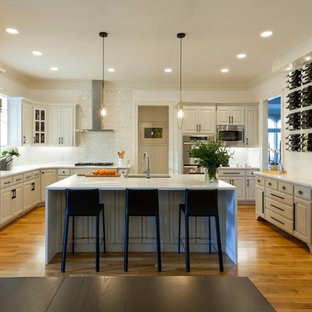 Design ideas for a medium sized modern l-shaped kitchen/diner in Raleigh with a double-bowl sink, raised-panel cabinets, beige cabinets, quartz worktops, white splashback, marble splashback, stainless steel appliances, plywood flooring, an island, yellow floors and white worktops.