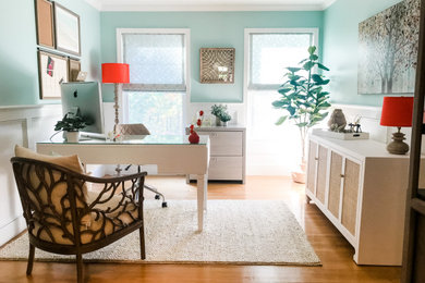 Mid-sized transitional freestanding desk medium tone wood floor and wainscoting study room photo in Other with blue walls
