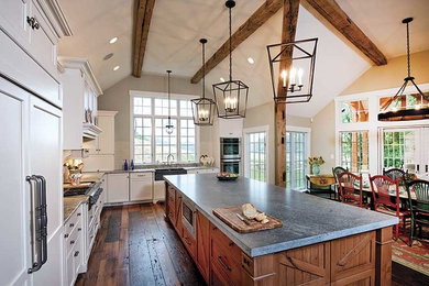 Large country l-shaped dark wood floor and brown floor eat-in kitchen photo in Philadelphia with a double-bowl sink, white cabinets, soapstone countertops, stainless steel appliances and an island