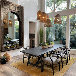 Large tropical open plan dining in Orange County with white walls, medium hardwood floors and brown floor.