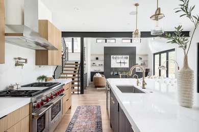 Design ideas for a large contemporary eat-in kitchen in Denver with an undermount sink, flat-panel cabinets, quartz benchtops, white splashback, engineered quartz splashback, stainless steel appliances, light hardwood floors, with island and white benchtop.