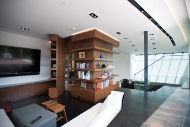 Inspiration for a mid-sized modern open concept medium tone wood floor living room library remodel in New York with white walls and a wall-mounted tv