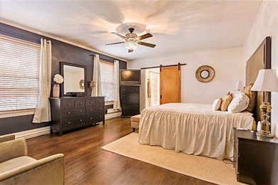 シカゴにある広いトランジショナルスタイルのおしゃれな主寝室 (白い壁、濃色無垢フローリング、暖炉なし、茶色い床)