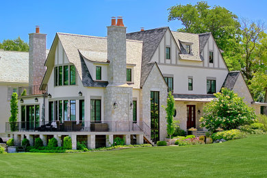Example of a huge french country beige two-story stone exterior home design in Chicago with a shingle roof and a brown roof