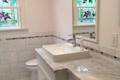 Mid-sized transitional master white tile and stone tile marble floor bathroom photo in Salt Lake City with shaker cabinets, white cabinets, a two-piece toilet, beige walls, a drop-in sink and quartzite countertops