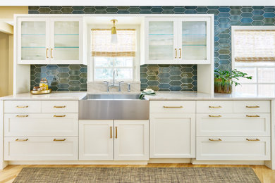 Example of a transitional u-shaped kitchen design in Minneapolis with recessed-panel cabinets, white cabinets, quartzite countertops, blue backsplash, an island and beige countertops