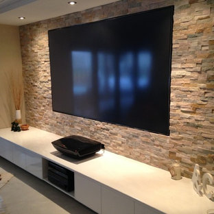 Example of a large minimalist open concept concrete floor home theater design in Sunshine Coast with multicolored walls and a media wall