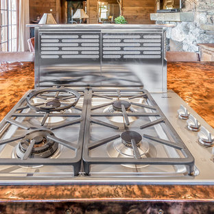 Réalisation d'une arrière-cuisine chalet en L de taille moyenne avec un évier 1 bac, un placard à porte plane, des portes de placard beiges, un plan de travail en cuivre, une crédence multicolore, une crédence en carreau de porcelaine, un électroménager en acier inoxydable, un sol en bois brun et un îlot central.