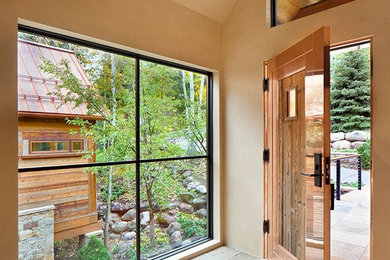 Large minimalist slate floor entryway photo in Denver with beige walls and a metal front door