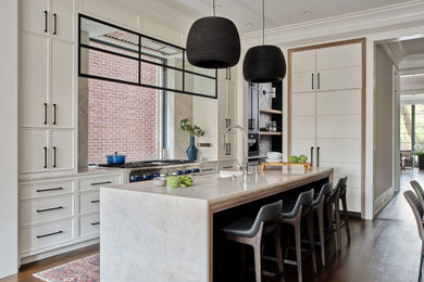 Inspiration for a transitional l-shaped dark wood floor and brown floor eat-in kitchen remodel in Chicago with white cabinets, marble countertops, window backsplash, paneled appliances, an island, gray countertops, a farmhouse sink and shaker cabinets