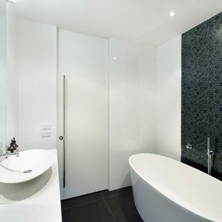 Immagine di una piccola stanza da bagno moderna con lavabo a bacinella, top in quarzo composito, vasca freestanding, piastrelle bianche, piastrelle in ceramica e pareti multicolore