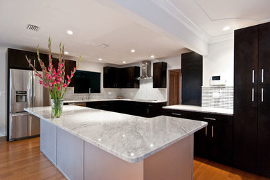 Inspiration for a mid-sized transitional u-shaped medium tone wood floor eat-in kitchen remodel in Orlando with flat-panel cabinets, dark wood cabinets, quartzite countertops, multicolored backsplash, ceramic backsplash and stainless steel appliances