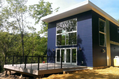 Example of a mid-sized minimalist blue two-story vinyl flat roof design in Cincinnati