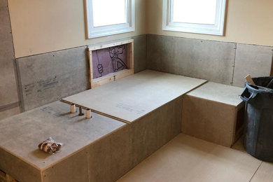 Large minimalist master multicolored tile and stone tile travertine floor and multicolored floor bathroom photo in Indianapolis with raised-panel cabinets, gray cabinets, a one-piece toilet, blue walls, an undermount sink, granite countertops, a hinged shower door and beige countertops