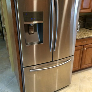 Inspiration för ett mellanstort vintage kök, med luckor med upphöjd panel, skåp i mellenmörkt trä, granitbänkskiva, brunt stänkskydd, rostfria vitvaror, terrazzogolv och en halv köksö