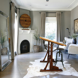 Ejemplo de despacho tradicional renovado con paredes grises, suelo de madera oscura, chimenea de esquina, escritorio independiente y suelo marrón