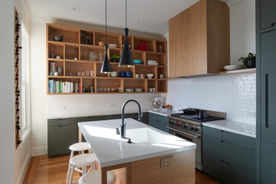 Inspiration for a midcentury l-shaped kitchen in San Francisco with an undermount sink, flat-panel cabinets, quartz benchtops, panelled appliances, medium hardwood floors, with island, white benchtop, grey cabinets, white splashback and brown floor.