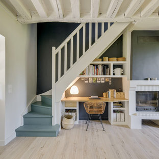 Imagen de despacho mediterráneo, de tamaño medio, con paredes negras, suelo laminado, chimenea tradicional, marco de chimenea de ladrillo, escritorio empotrado y suelo beige