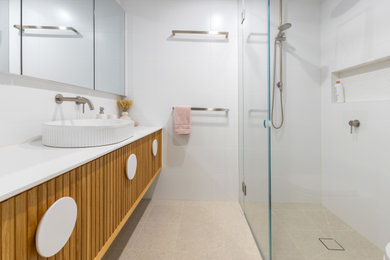 Design ideas for a medium sized modern ensuite bathroom in Melbourne with freestanding cabinets, light wood cabinets, a walk-in shower, white tiles, porcelain tiles, white walls, porcelain flooring, a vessel sink, engineered stone worktops, beige floors, an open shower, white worktops, a wall niche, a single sink and a floating vanity unit.