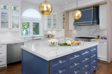 Inspiration for a transitional l-shaped kitchen in Toronto with quartz benchtops, a double-bowl sink, glass-front cabinets, white cabinets, white splashback, stainless steel appliances, medium hardwood floors and with island.