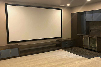 На фото: большой изолированный домашний кинотеатр в современном стиле с бежевыми стенами, ковровым покрытием, проектором и бежевым полом