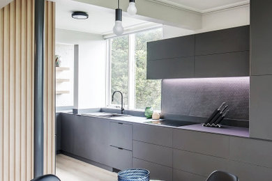 Mid-sized contemporary u-shaped eat-in kitchen in Sydney with a single-bowl sink, flat-panel cabinets, brown cabinets, tile benchtops, brown splashback, ceramic splashback, stainless steel appliances, light hardwood floors, no island, brown floor, black benchtop and exposed beam.