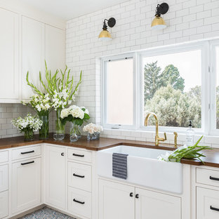 アルバカーキのモダンスタイルのおしゃれなランドリールーム (エプロンフロントシンク、落し込みパネル扉のキャビネット、白いキャビネット、木材カウンター、白い壁、テラコッタタイルの床、青い床、茶色いキッチンカウンター) の写真